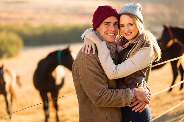 Happy young couple in horse ranch