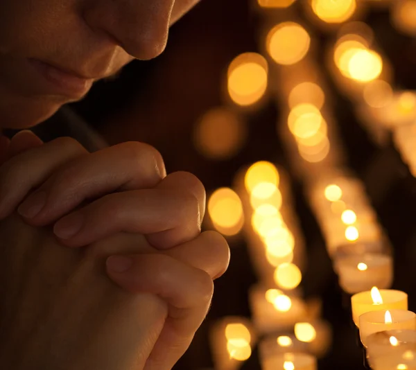 Woman praying in church cropped part of face and hands closeup p