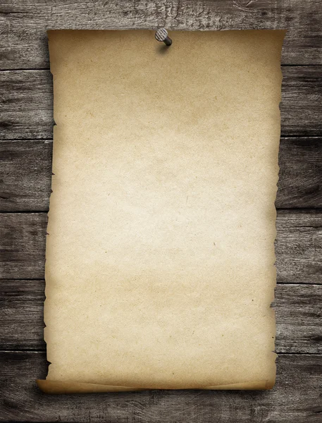 Old wanted paper or parchment pinned by nail to grunge wooden ba — Stock Photo #34127633