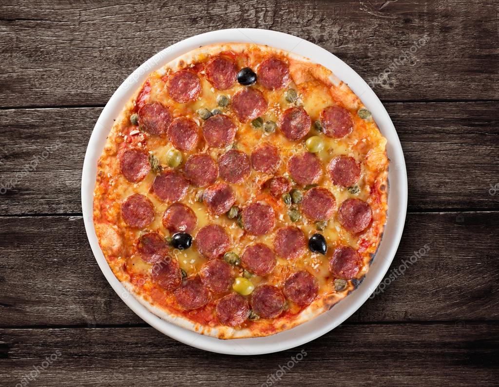 Italian salami pizza top view on wooden table — Stock Photo © Andrey