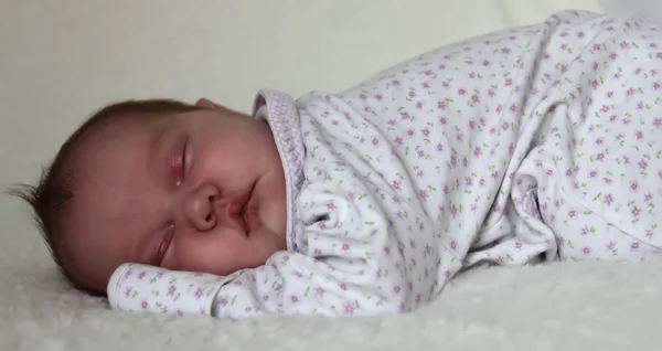 Monthly baby sleeps on a white blanket