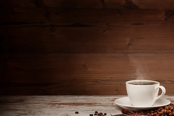 White cup of coffee over wooden background