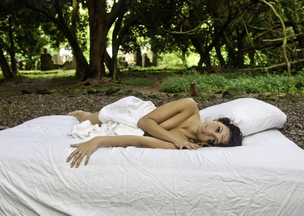 Girl in bed in the woods