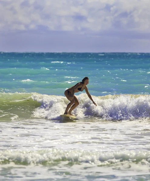 Blond girl surfing the waves