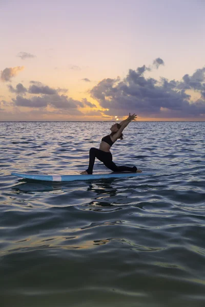 Woman doing yoga on a paddle board