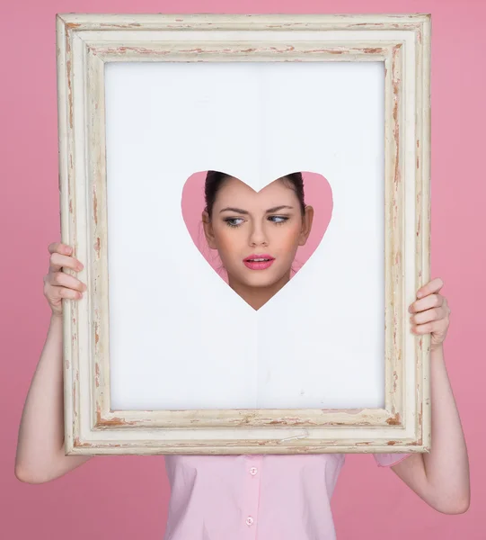 Beautiful woman with her face framed by a heart