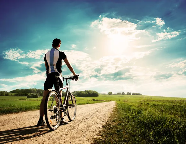 Man with a Bike on Beautiful Nature Background