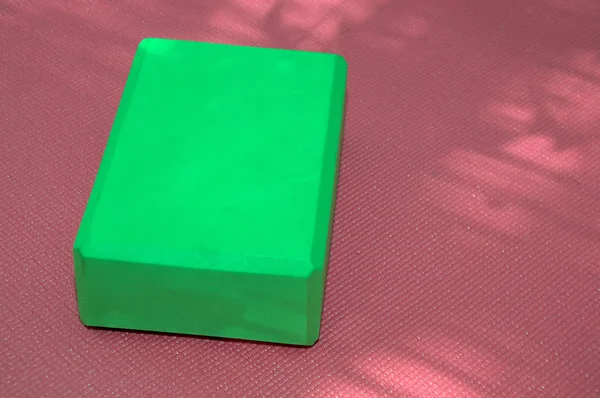 Pink yoga mat and green block