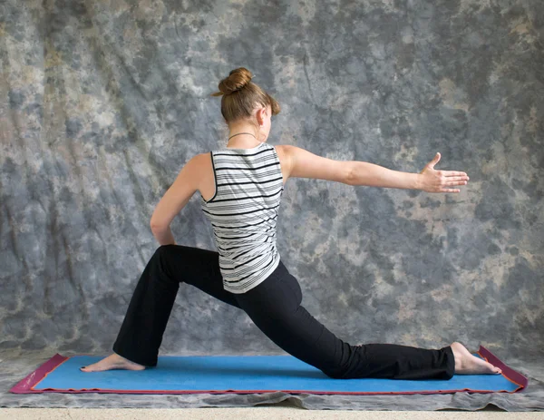 Woman doing Yoga posture rotated Low Lunge or Ashwa Sanchalanasa