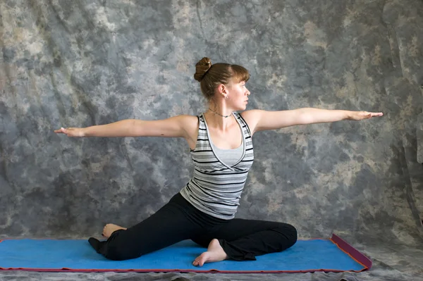 Young woman doing Yoga posture Virabhadrasana II or seated warri