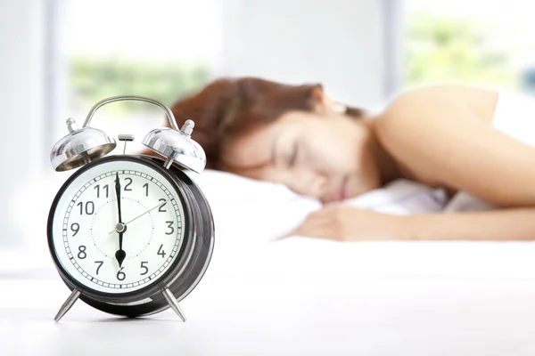 The clock and Young beautiful woman sleeping