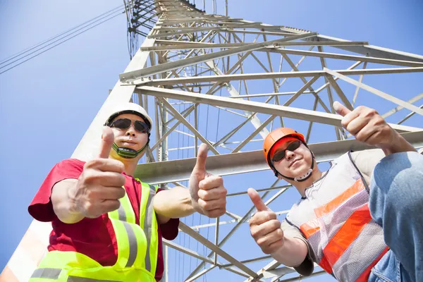 Two power line workers with thumbs up