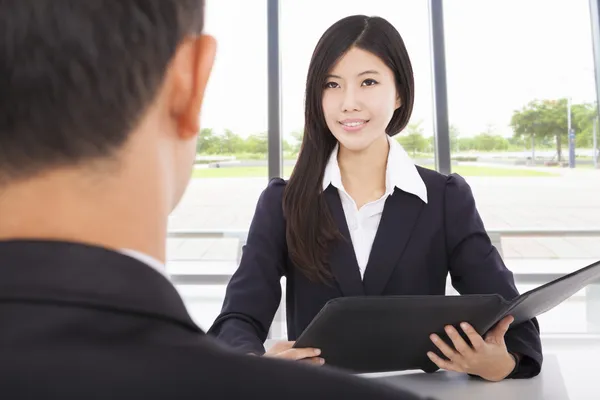 Smiling businesswoman interviewing with businessman in office