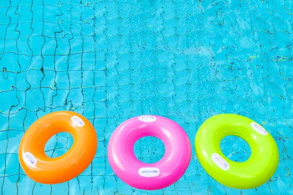 Three colorful swimming pool rings on the water
