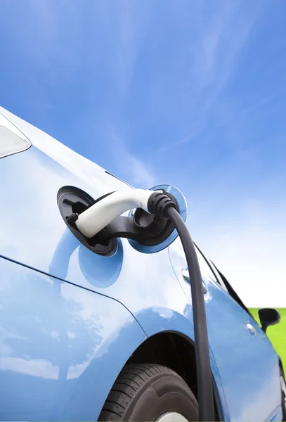 Charging of an electric car with cloud background