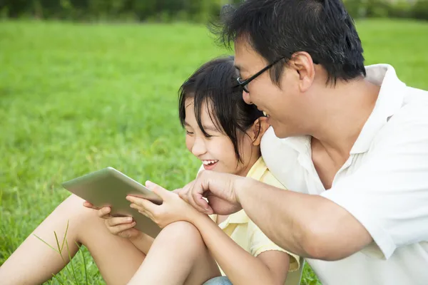 Father teaching little girl using tablet pc