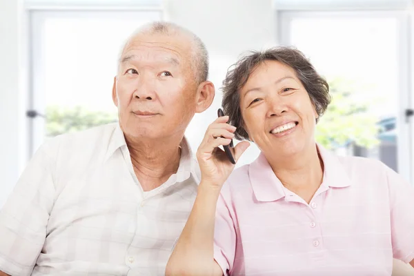 Happy seniors couple talking on the phone