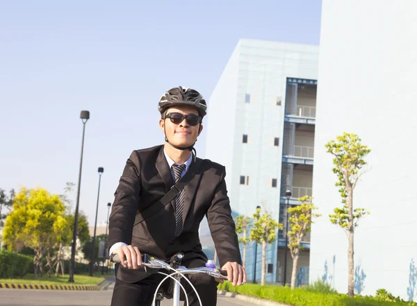 Businessman riding a bicycle to workplace for protecting environ