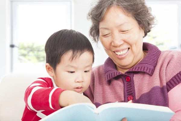 Grandmother and grandson are reading story book together