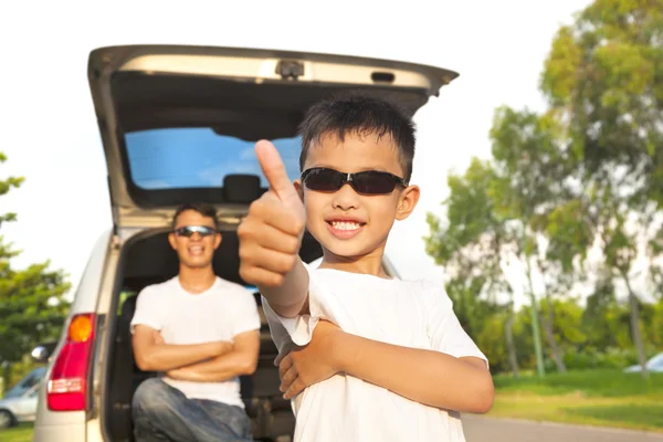 Cool boy thumb up and father across arms with car