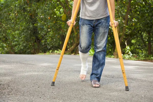 Closeup of leg on bandage with crutches