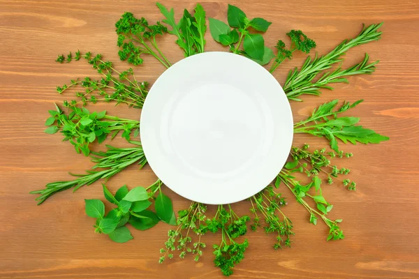 Fresh Herbs Collection as Border Around White Plate