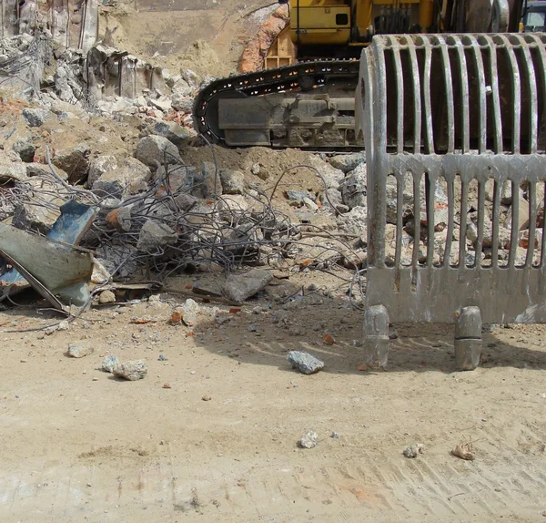 Excavator and demolition rubble on an industrial construction si