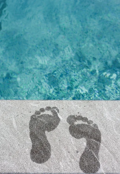 Two wet foot steps by swimming pool