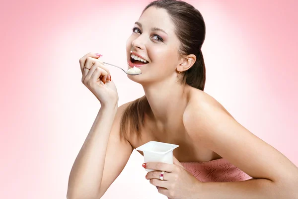 Charming woman eating yogurt