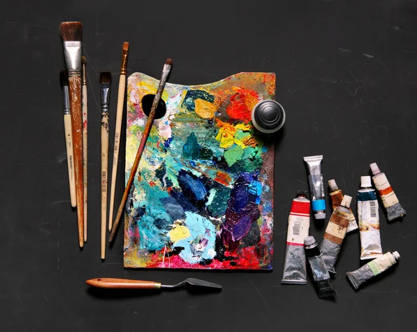 Professional brushes with a palette knife and tubes of paint