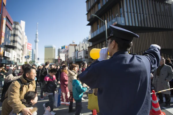 Police man conducting thousand of to the the Asakusa Kann