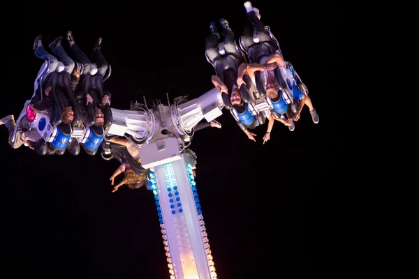 People having fun in a roller coaster at night