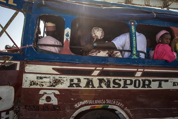 People traveling into an old bus local bus in Senegal