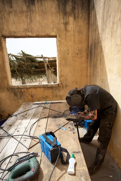 Welder at work in old house in Africa