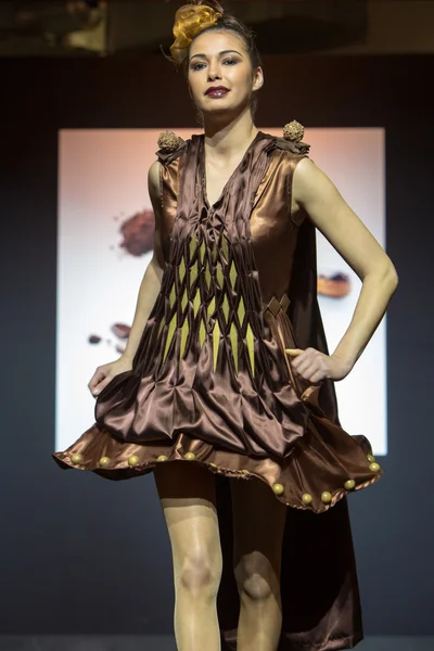 Model walking with chocolate dress during fashion show