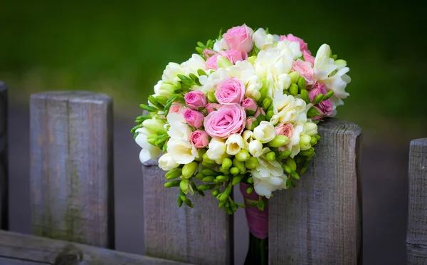 Wedding bouquet on rustic country fence — Stock Photo #21607657