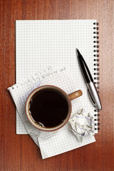 Cup of coffee, notebook and pen