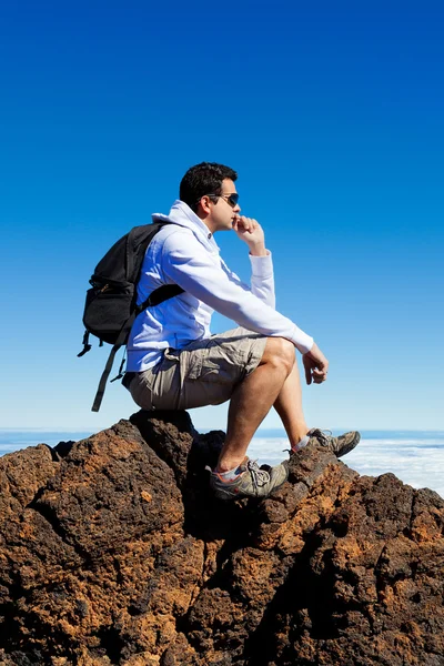 Young Man Having a Rest in a High Peak Over Clouds in Teide Moun