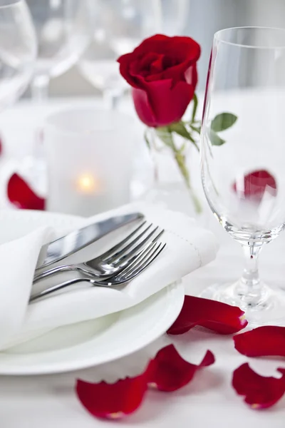 Romantic dinner setting with rose petals