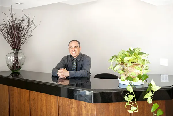 Smiling man standing at office reception