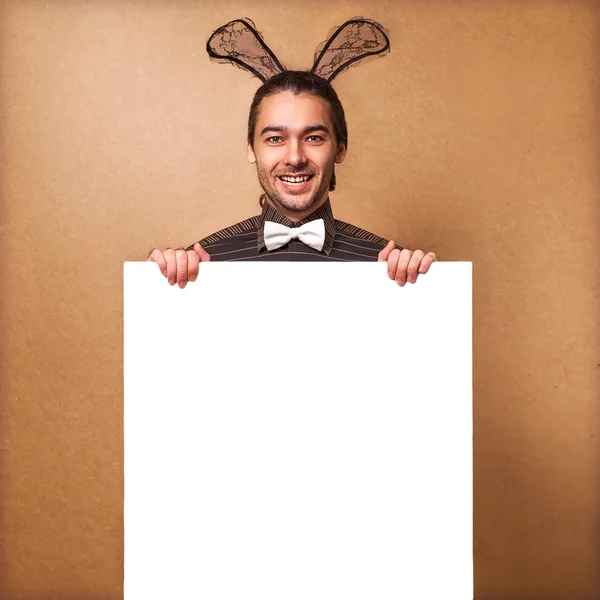 Fashion guy in bunny with rabbit ears holding white board. Sale.