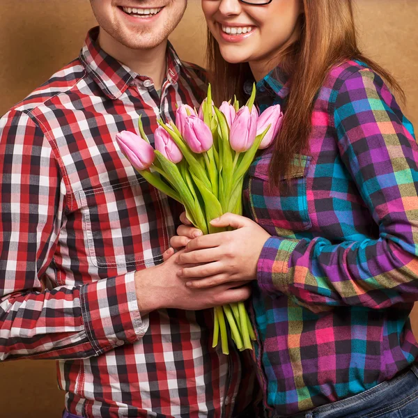 Valentine\'s day. Man and woman holding a bouquet of tulips in ha