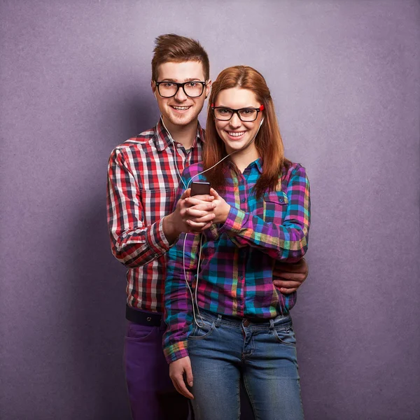 Young couple listening music together. Hipster style.