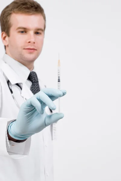 Professional doctor with medical syringe in hands