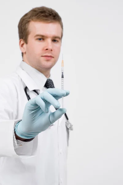 Professional doctor with medical syringe in hands