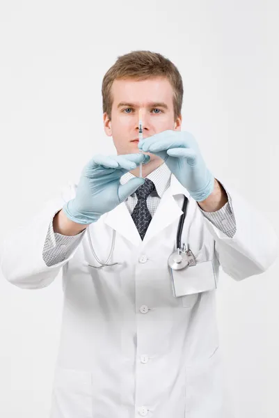 Doctor with medical syringe in hand ready to make injection