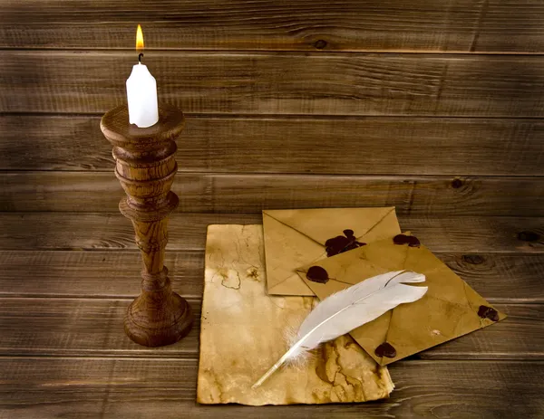 Feather, old paper and candle