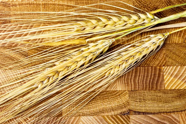 Wheat Ears on the Wooden Table. Sheaf of Wheat over Wood Backgro