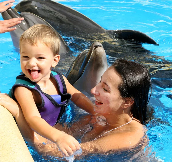 Happy beautiful young woman with a small child laughs and swims