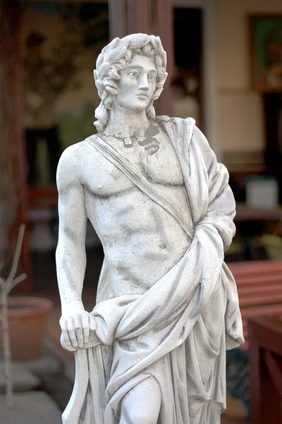 Classical stone sculpture of a young male musician with naked to